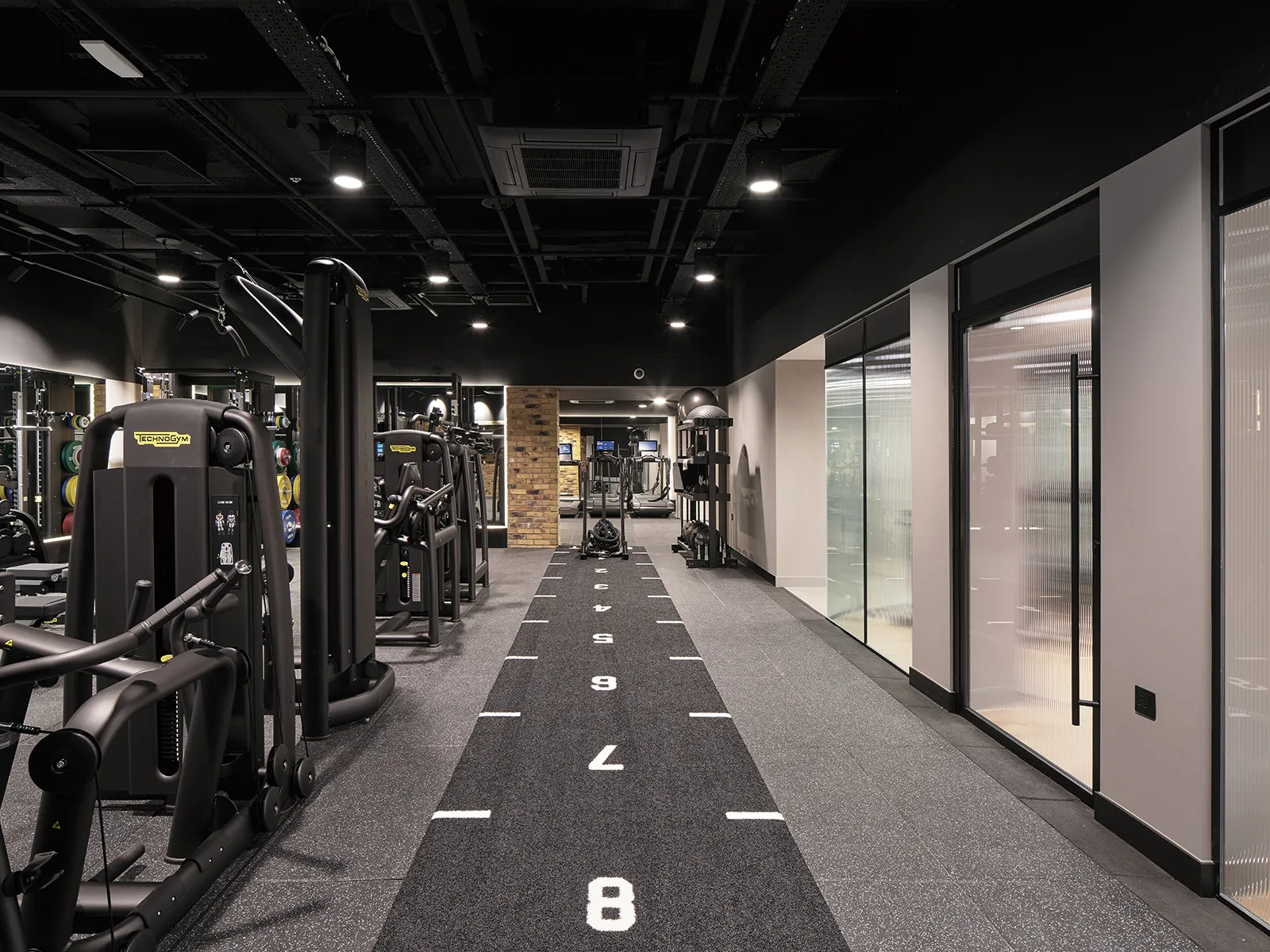 Gym floor with weights machines and a marked sprint track